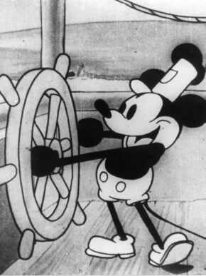 Steamboat Willie aboard a steam ship holding the ships wheel and tapping his foot.