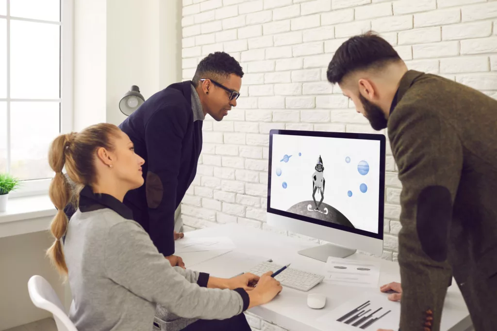 3 people watch an explainer video in an office.